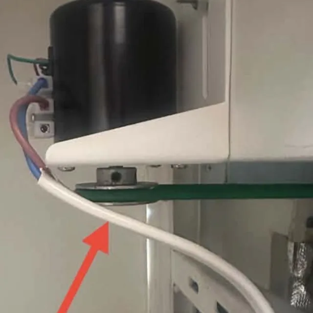 Green nylon drive belt on the motor pulley under the motor of a 99 Spoons Ice Cream Machine, marked with a red arrow